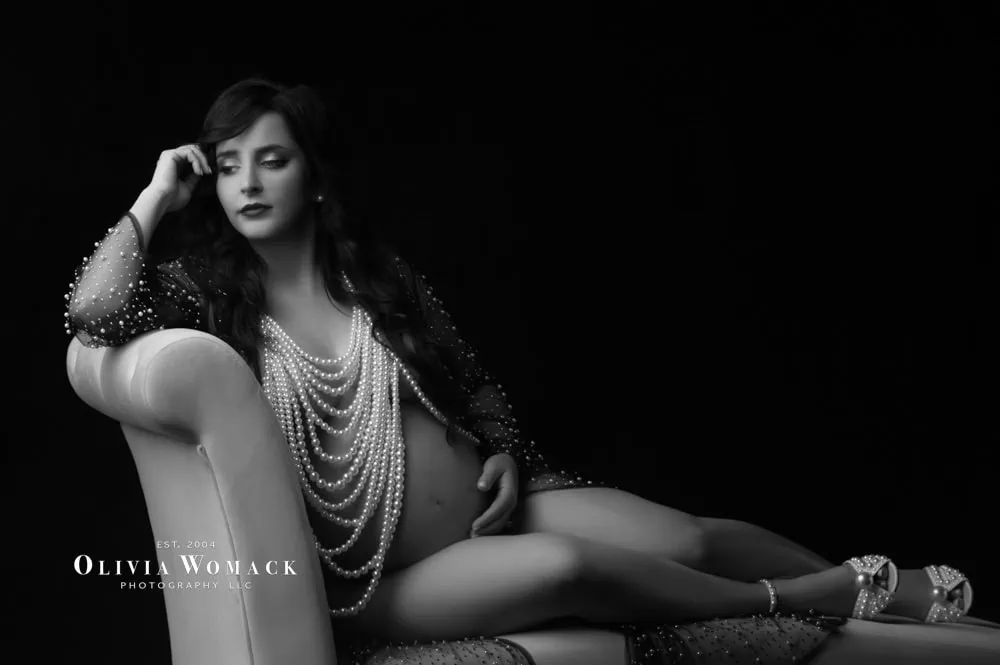 Elegant woman posing in beads on chaise lounge