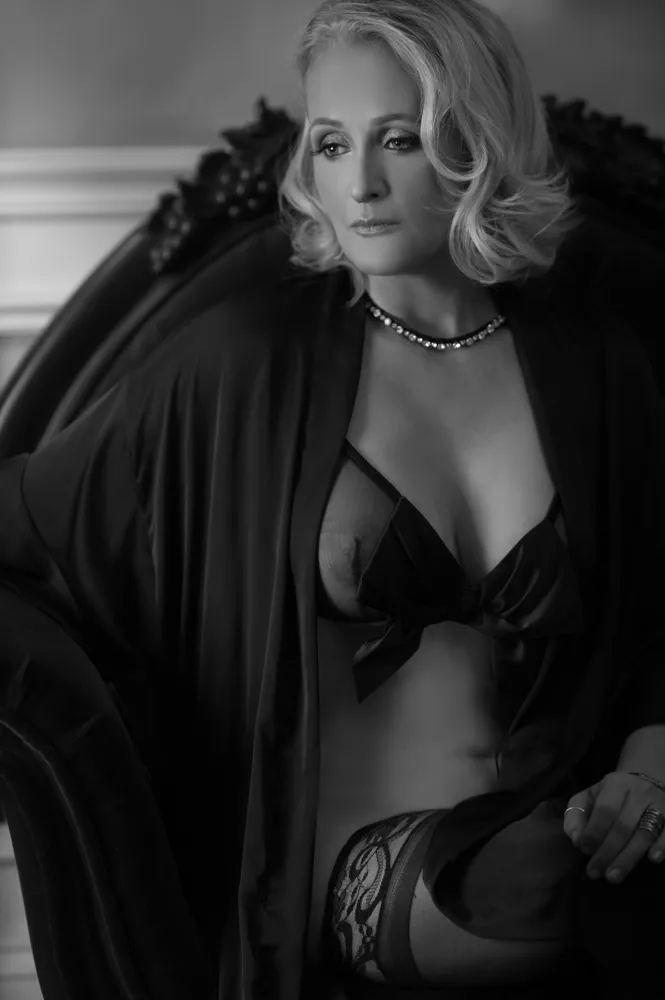 Elegant woman in lingerie with pearl necklace and cape