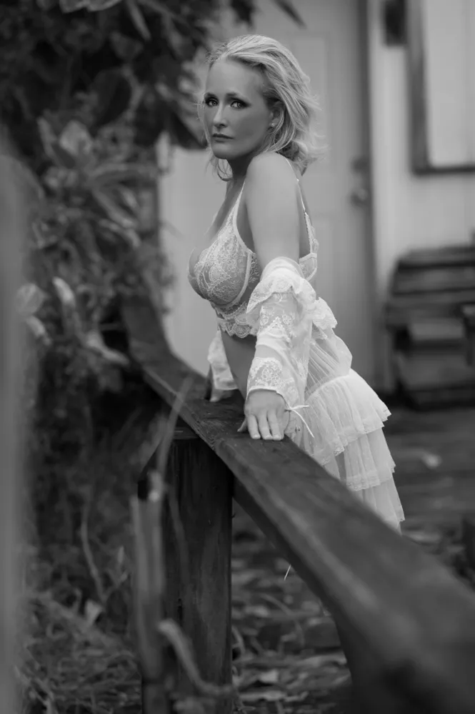 Woman in vintage lingerie posing by wooden railing