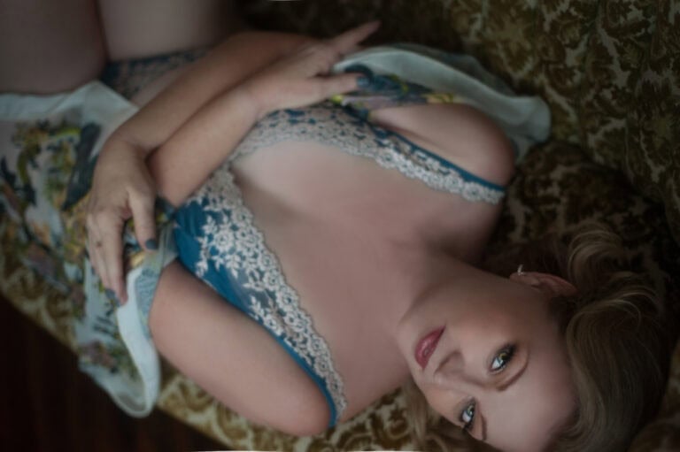 Woman in blue lace lying on patterned couch