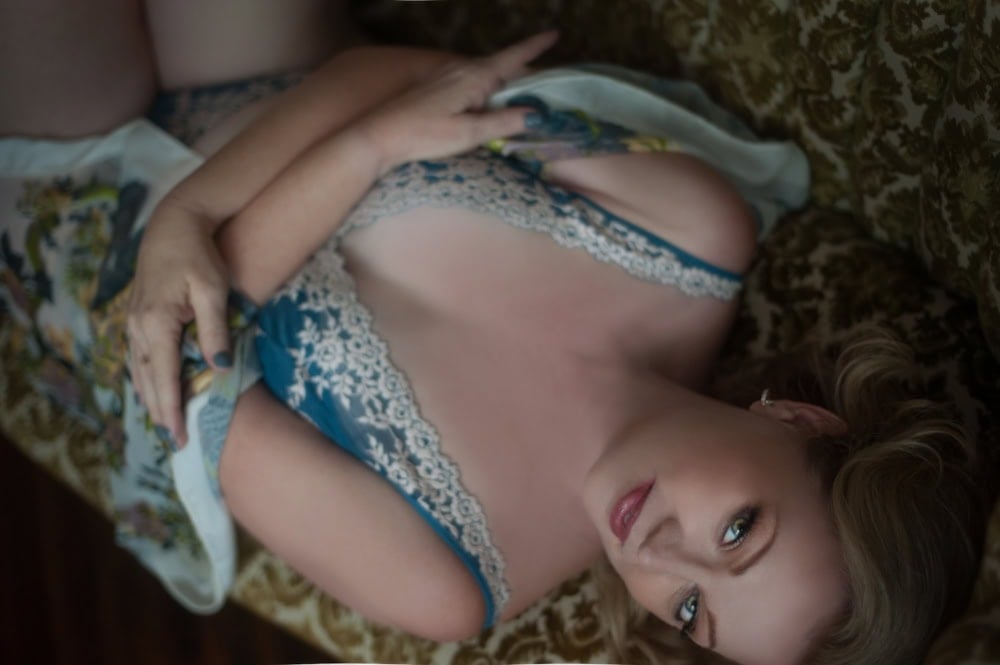 Woman in blue lace lying on patterned couch