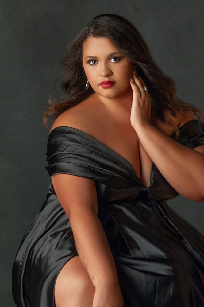 Confident woman in elegant black dress posing